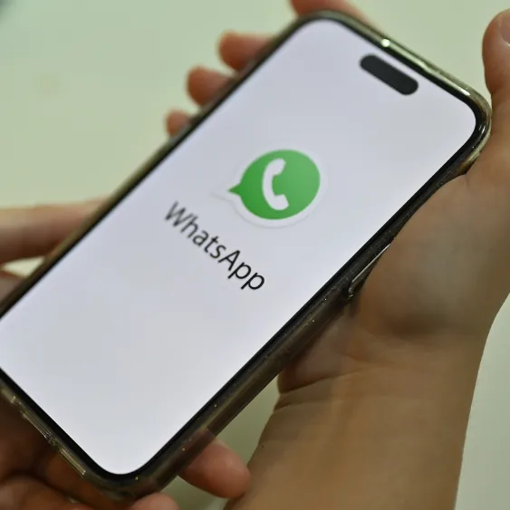 Mão segurando um celular com o WhatsApp aberto para agendar o atendimento