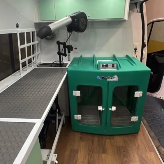 Interior da van de atendimento da Cristal Pet, com mesa de tosa, secador e caixa de secagem